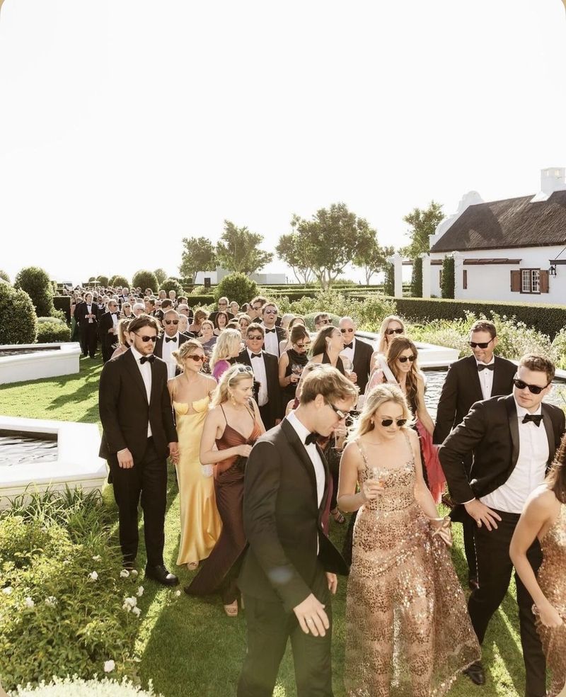 guests in black tie crossing a formal garden
