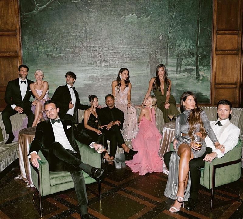 an evening party in black tie and jewel-tone gowns
