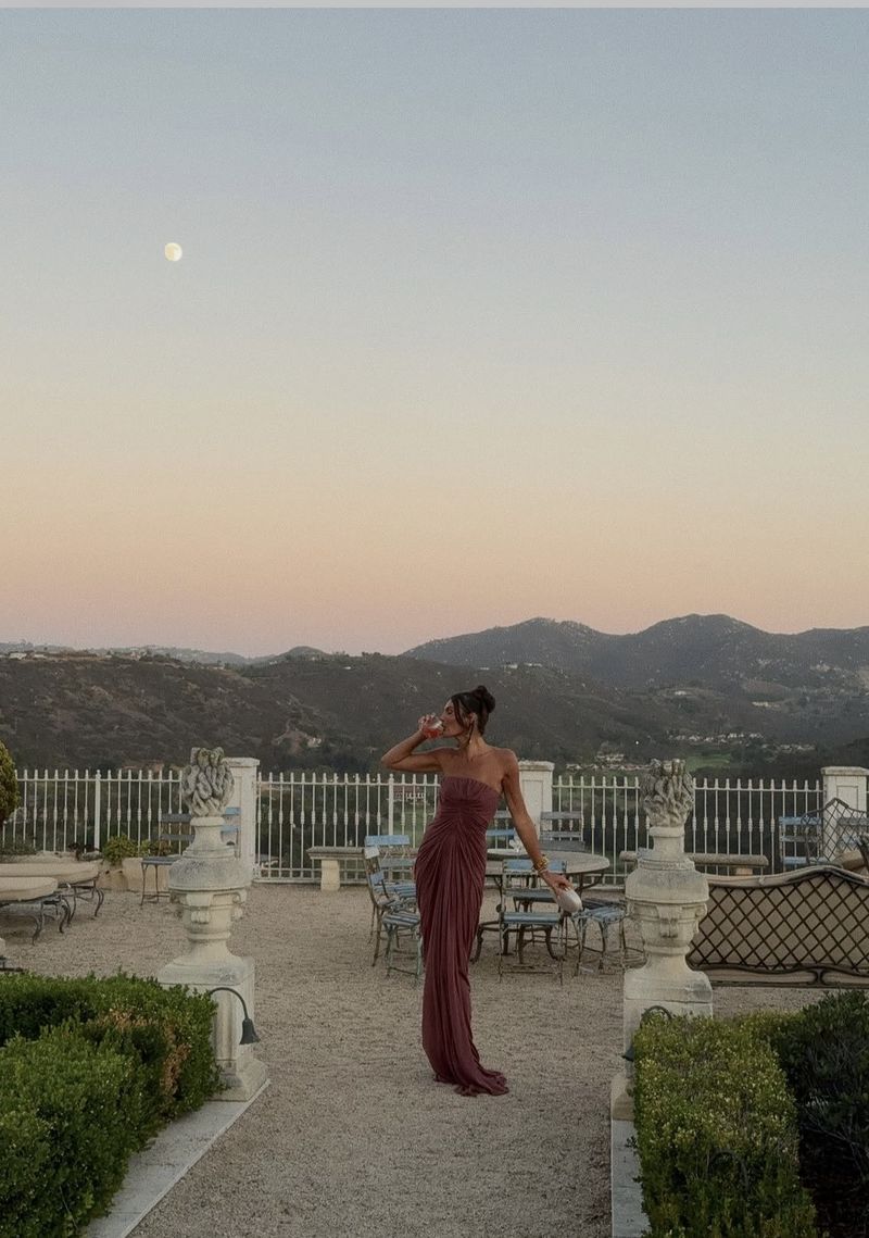 a dusky rose gown on a terrace at dusk
