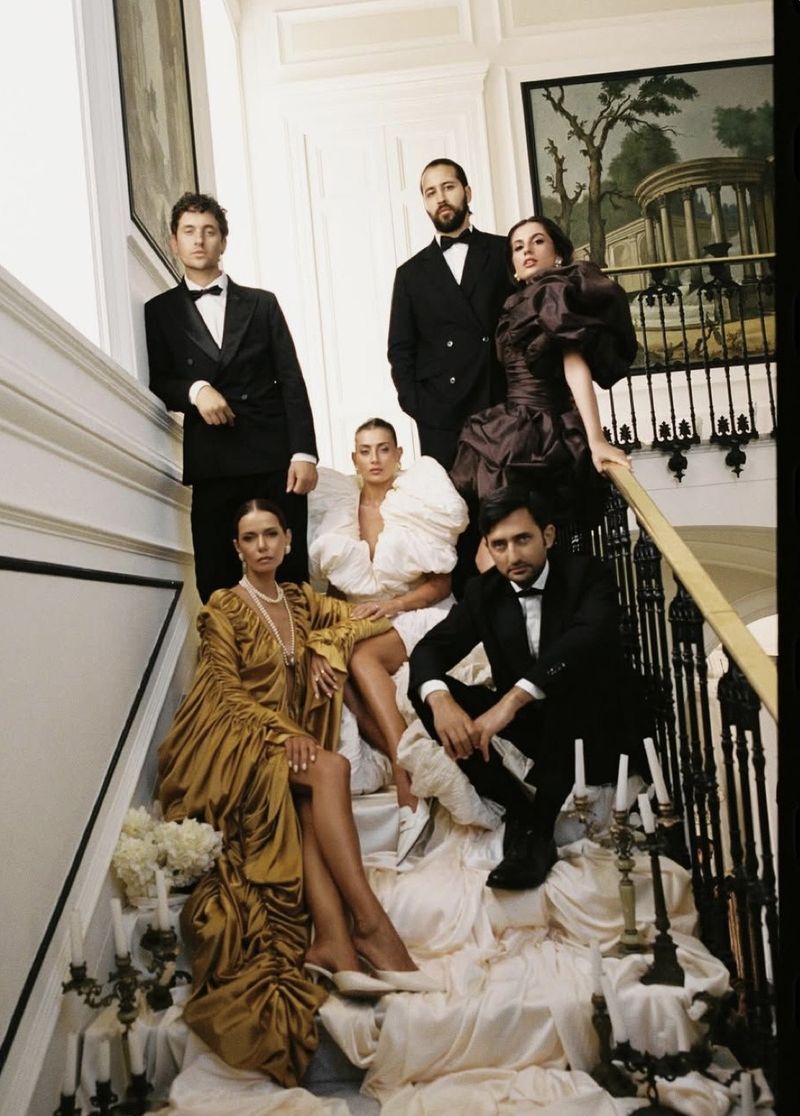 an evening party on a staircase, black tie and sculpted gowns